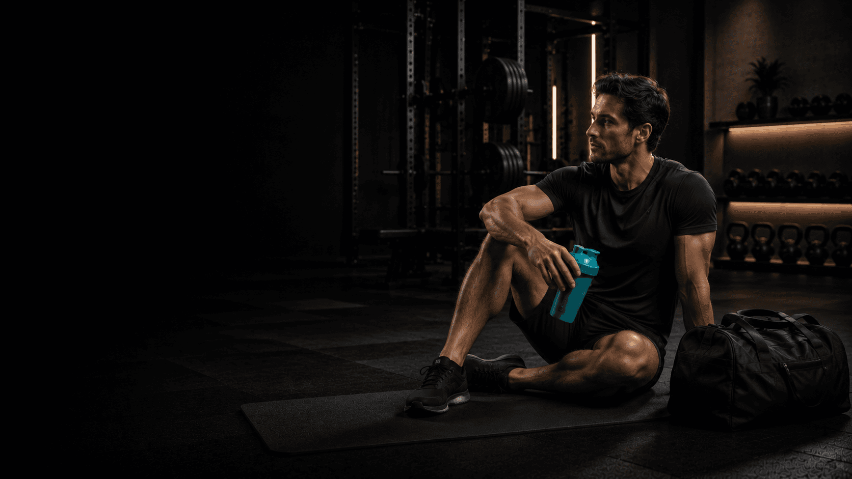 Hombre descansando en el gimnasio con su shaker